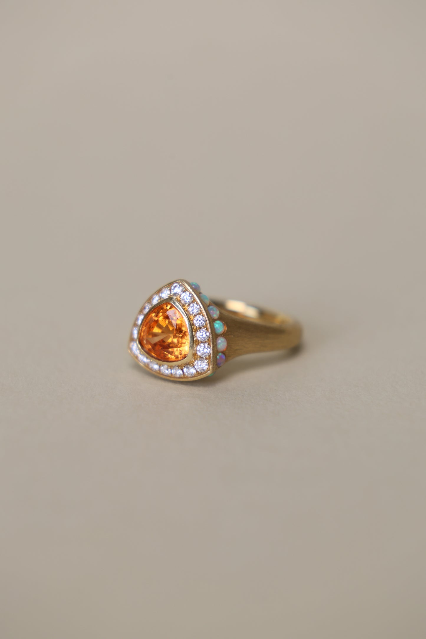 Trillion cut spessartine ring in 18k yellow gold with opal and diamond