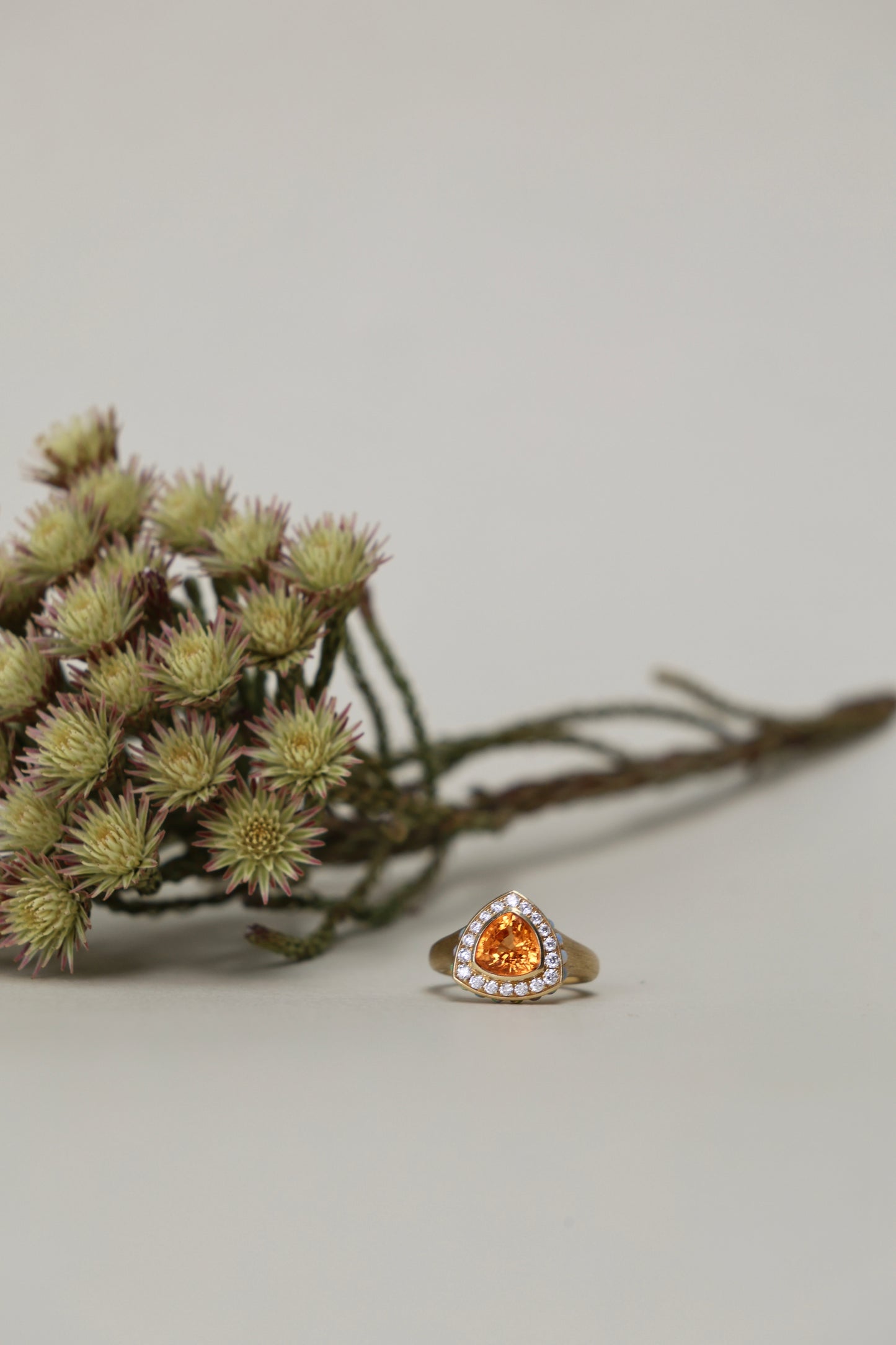 Trillion cut spessartine ring in 18k yellow gold with opal and diamond