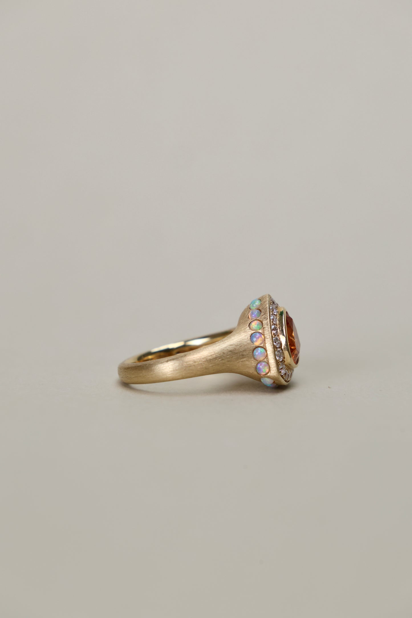 Trillion cut spessartine ring in 18k yellow gold with opal and diamond