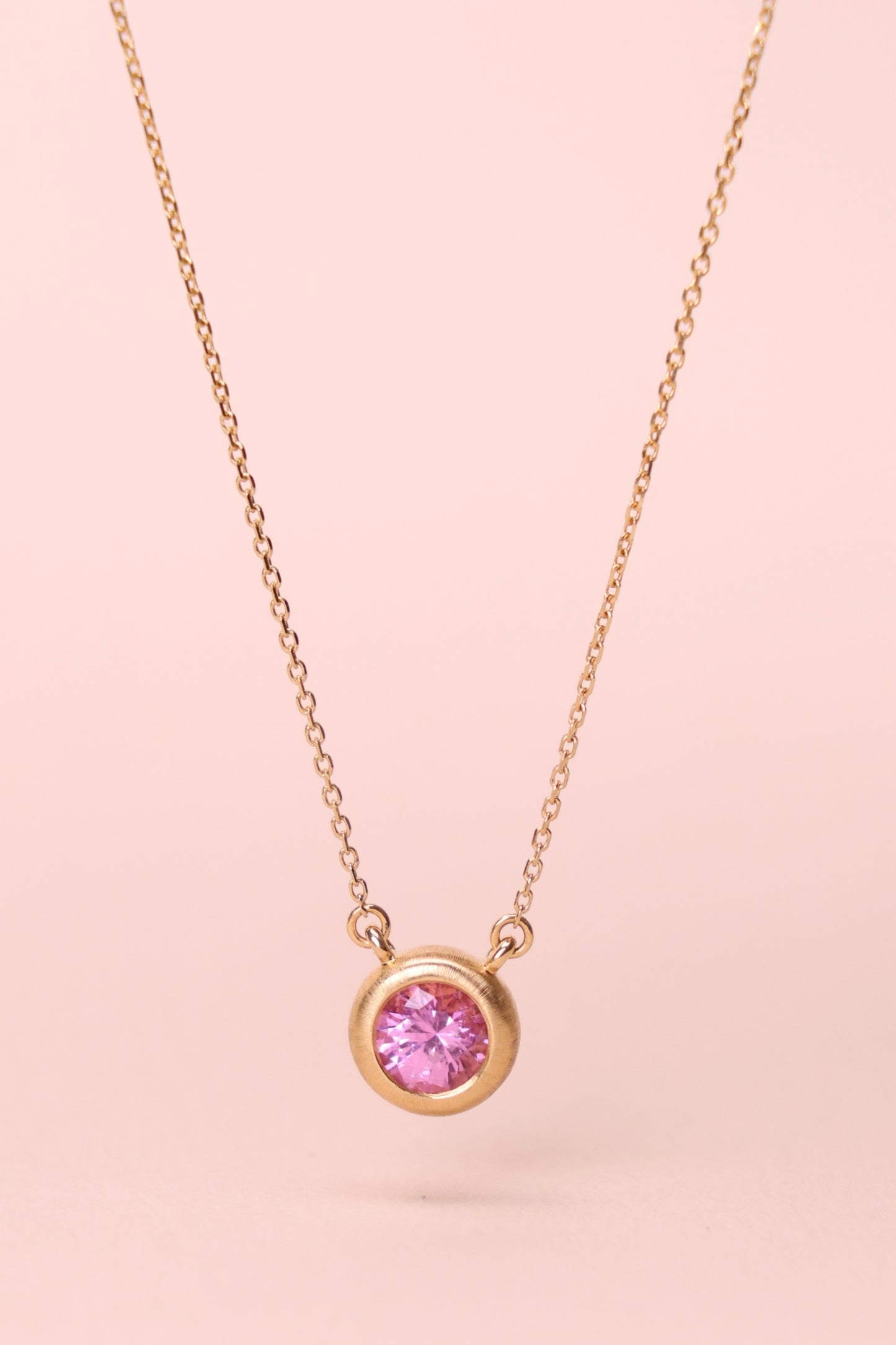 Bezel-set padparadscha necklace in 18k yellow gold